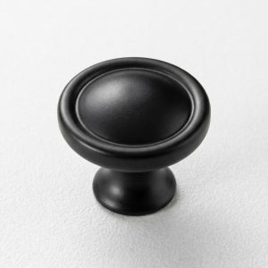 Primer plano del tirador tipo pomo o botón inglés de diseño circular color negro mate (Botón Inglés).
